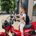 街で赤いバイクに夢中の息子を撮った→どれどれ…ん？？奥に真っ赤な金髪男性の『圧』が…「奇跡のツーショット」「寝癖でよく歩いてます」 – Togetter